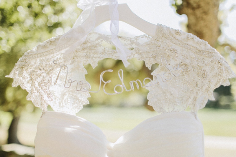 white capelet dress on hanger with bride's name, photo by Benj Haisch