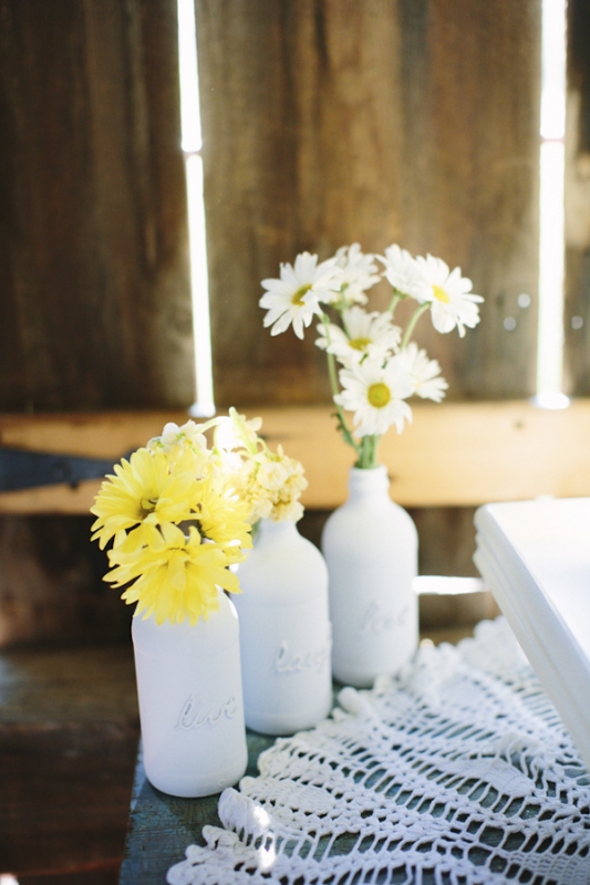 white milk bottles with yellow and white daisies, photo by Dan Stewart Photography