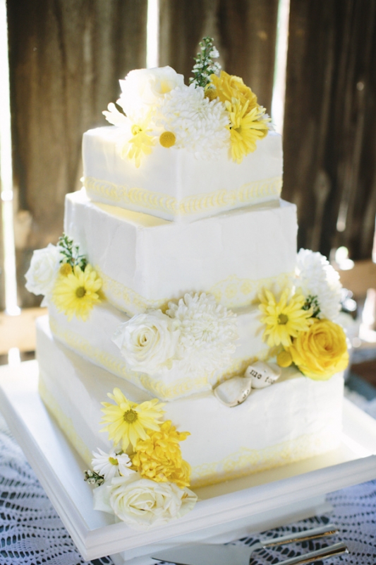 square tiered white cake with white and yellow daisies and roses, photo by Dan Stewart Photography
