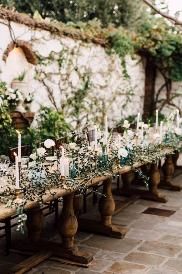 Tuscan-Inspired Wedding Reception with Light Blue Vases, White Candles, and Cascading Greenery