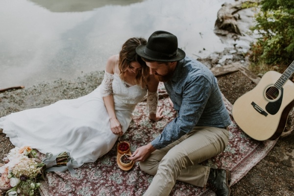 Elopement Picnic By A River With Guitar and Floral Blanket