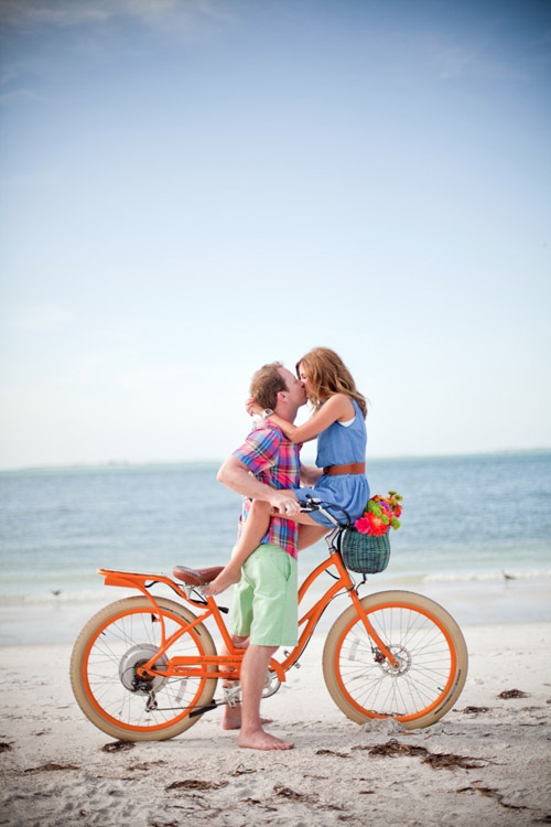 summer engagement photo on the beach with an orange bicycle by Slaton Weddings | via junebugweddings.com