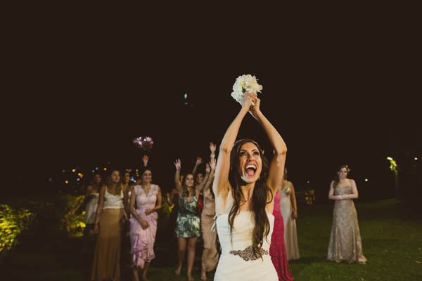 breathtaking outdoor wedding in Brazil tossing the bouquet, photo by Marina Lomar | via junebugweddings.com