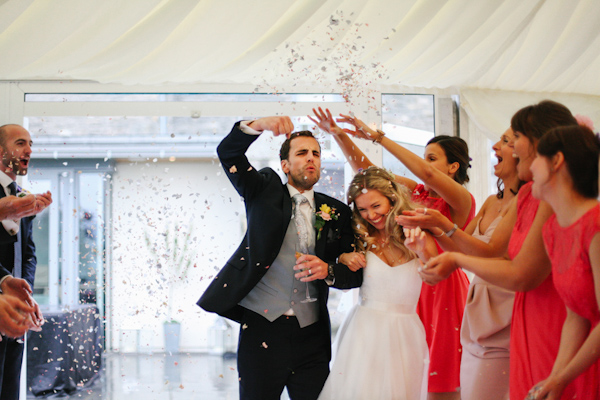 couple's confetti entrance, photo by Sansom Photography | via junebugweddings.com