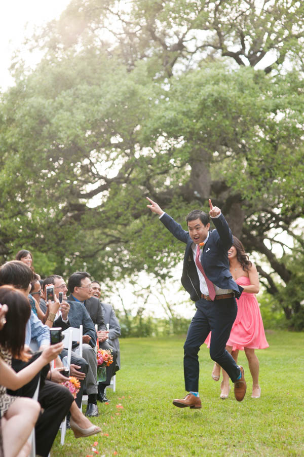 excited groom dancing down the aisle