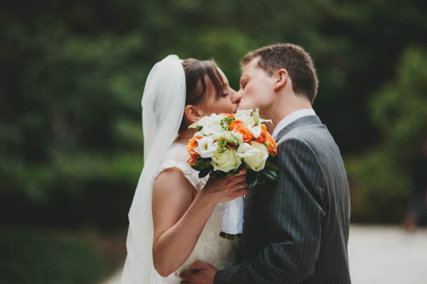 couple's kiss with bouquet