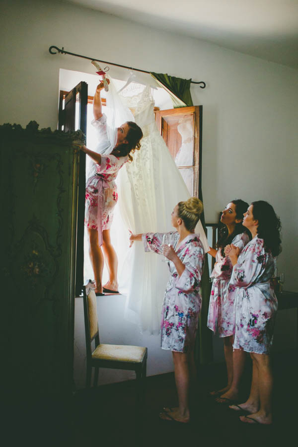 bride and bridesmaids getting the dress