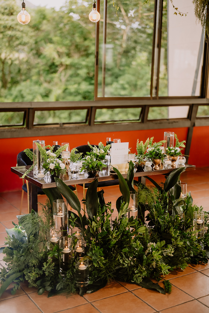 wedding sweetheart table surrounded by greenery