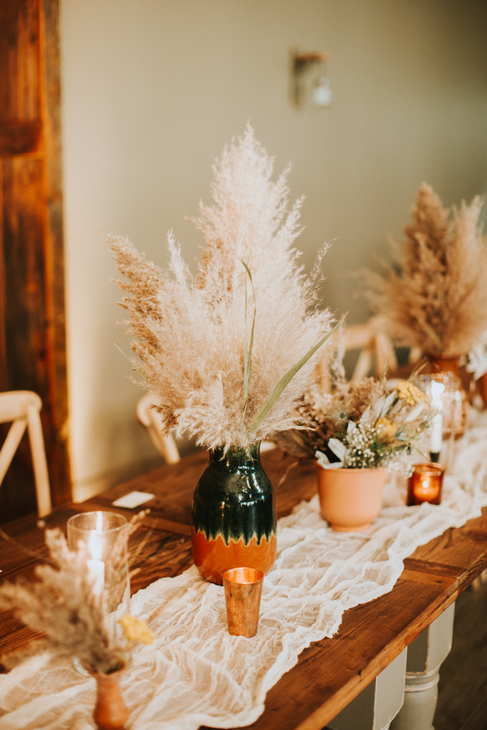 table decor with pampas grass, candles, and lace