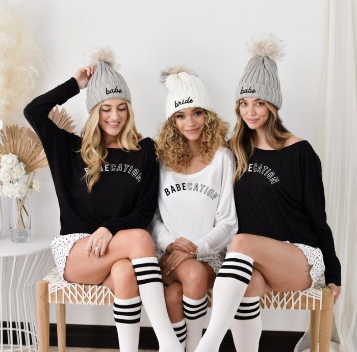 three women wearing beanies