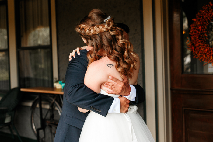 bride and groom embracing before Moore's cove falls wedding