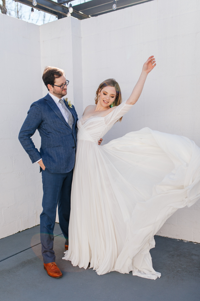 groom and bride posing and bride's dress flowing