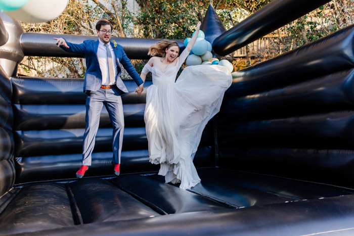 couple jumping in black sand beach bouncy house