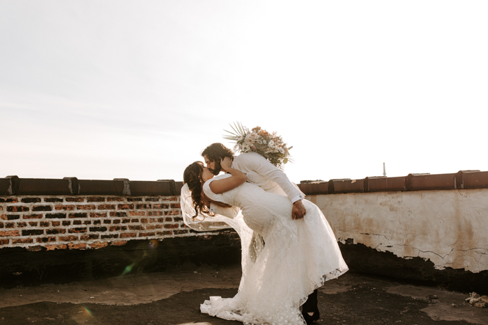 eloping couple kissing on a rooftop