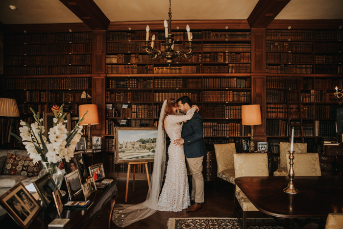 Tissington hall wedding couple kissing in library