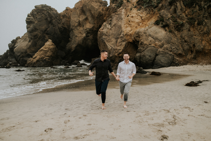 couple running in the sand for their beach wedding