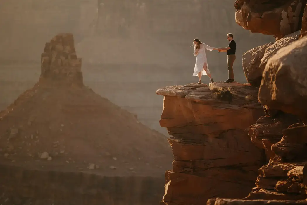 couple looking off cliff in Utah
