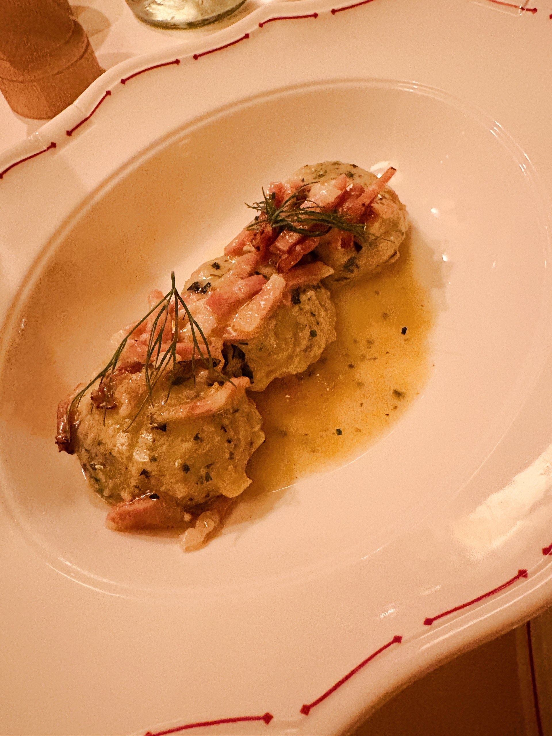 Tyrolean dumplings topped with crisp cured ham and dill, served at dinner at Castel Badia